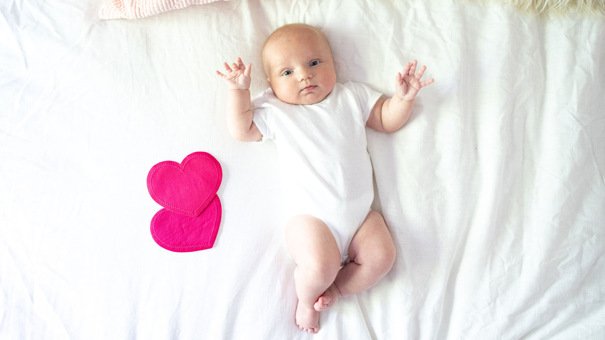 baby on the bed with Bamboobies washable nursing pads